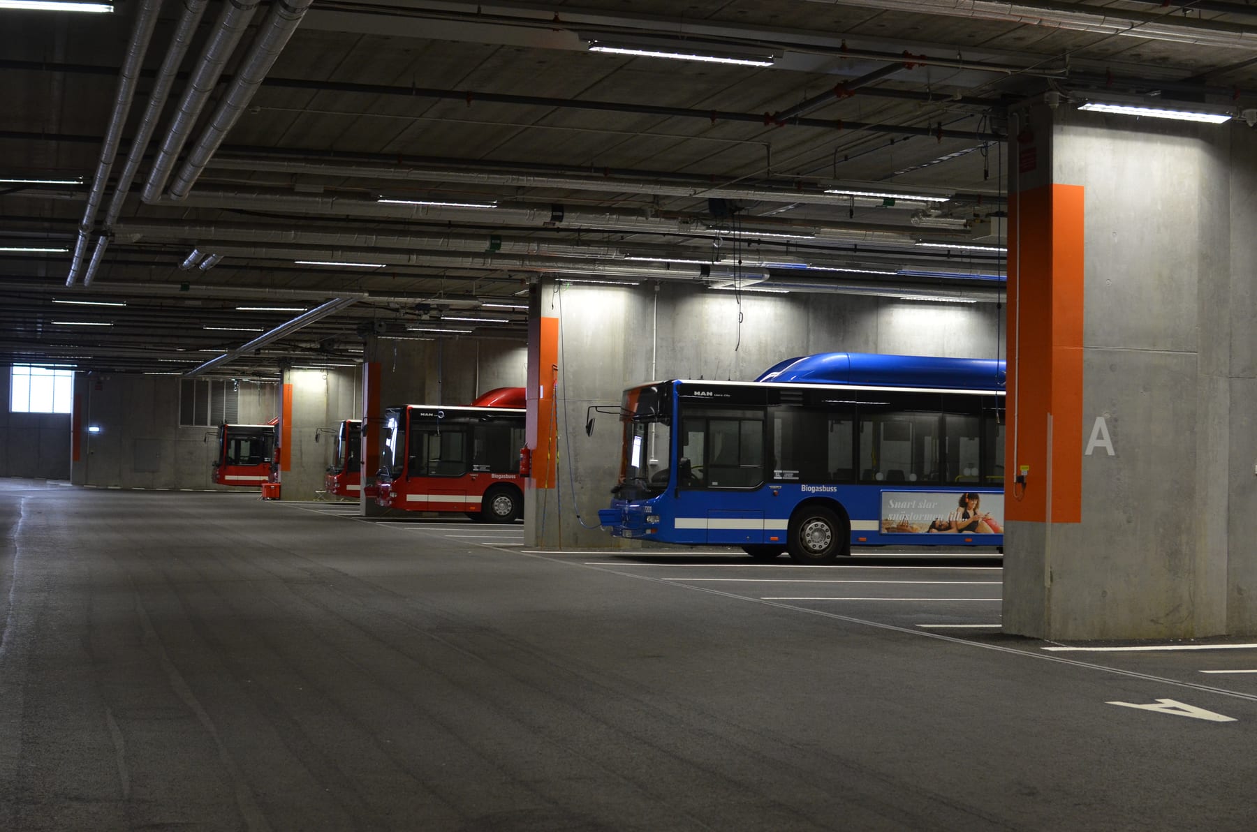 Red and blue buses parked in a Stockholm bus depot